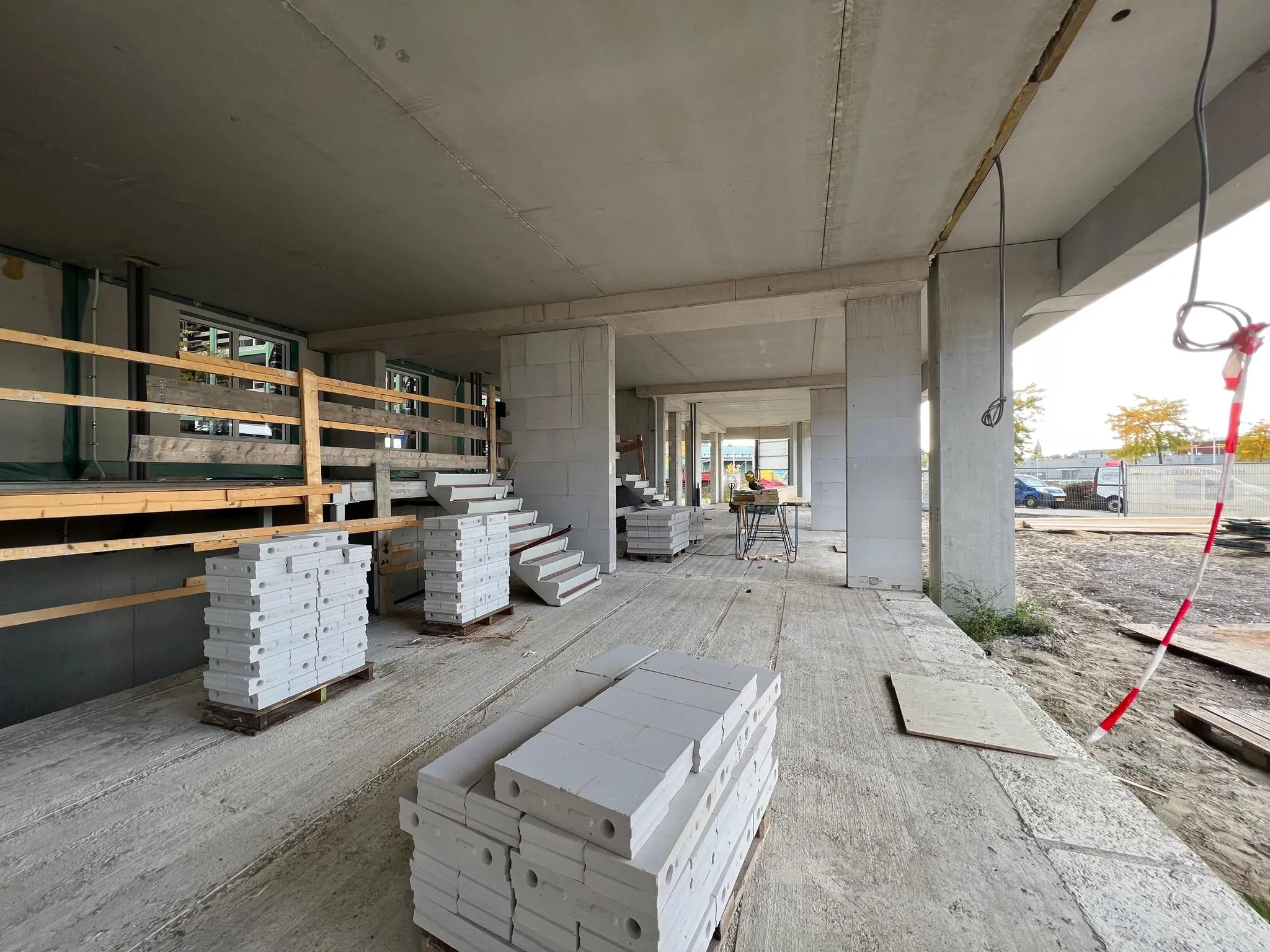 Bouwplaats aan de Cartesiusweg met betonnen constructie, stapels bouwmateriaal en een tijdelijke trap.