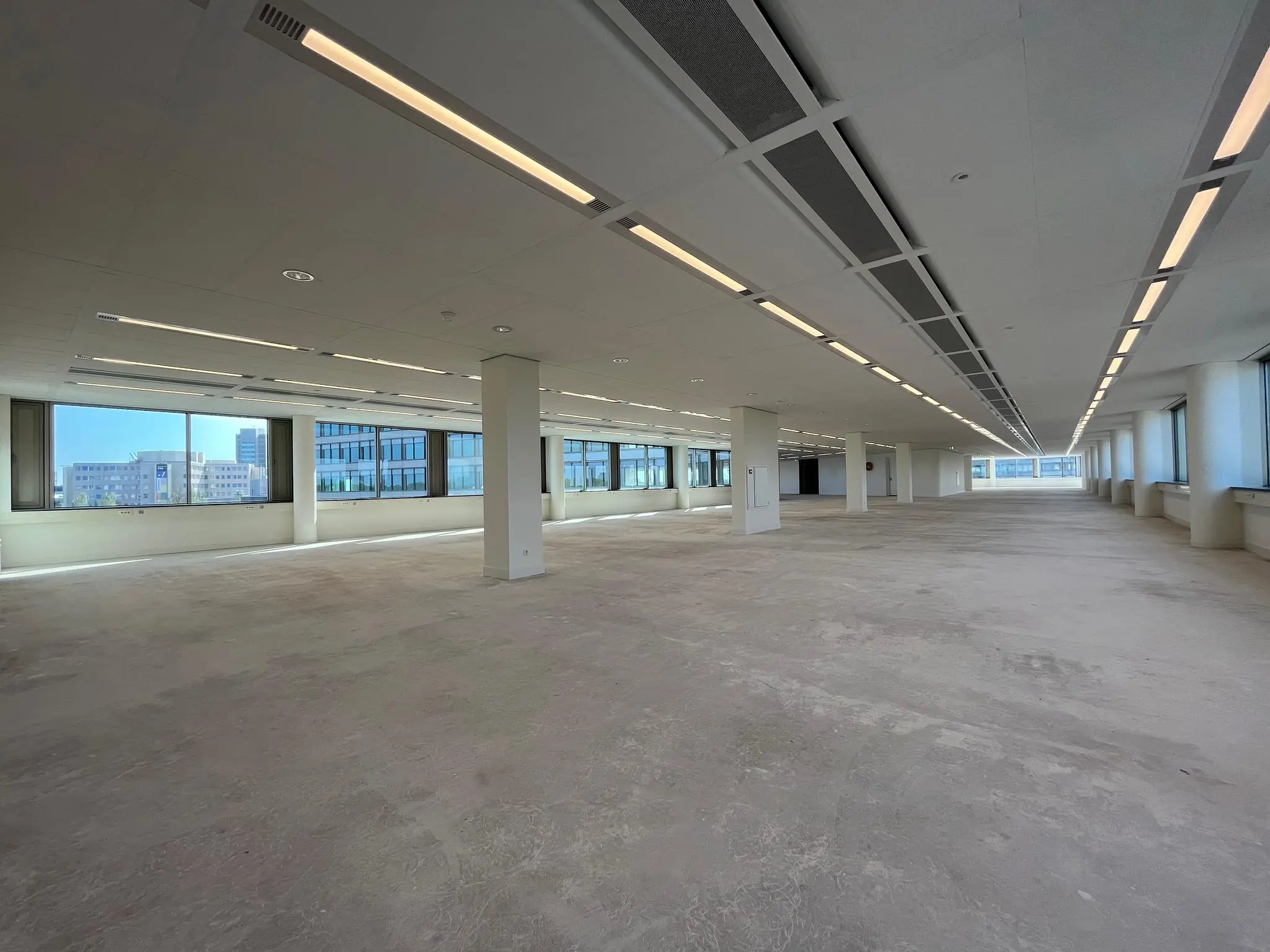 Leeg kantoorpand aan de Europalaan met grote ramen en systeemplafondverlichting.