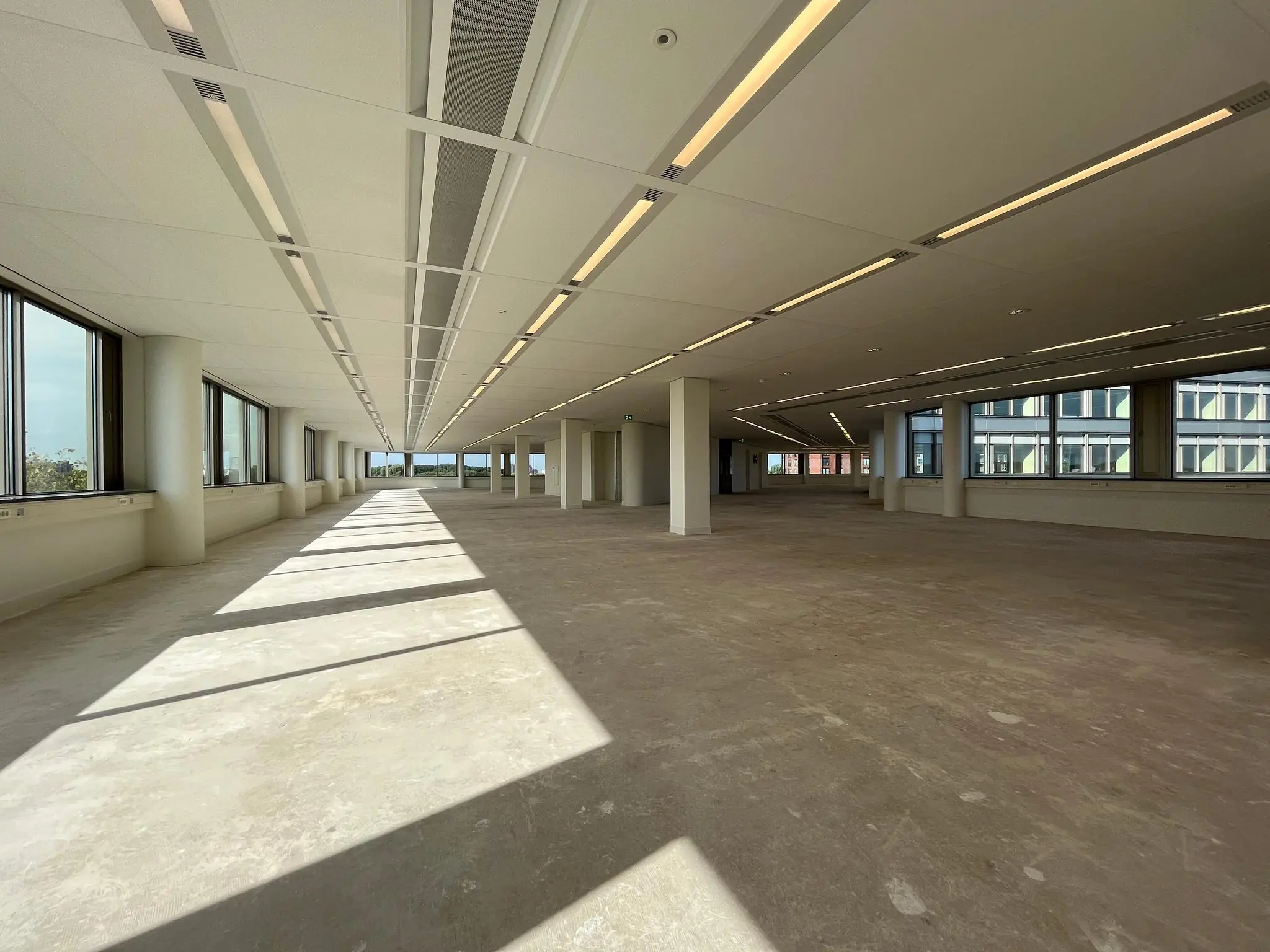 Leeg kantoorpand aan de Europalaan met grote ramen en veel natuurlijk licht.