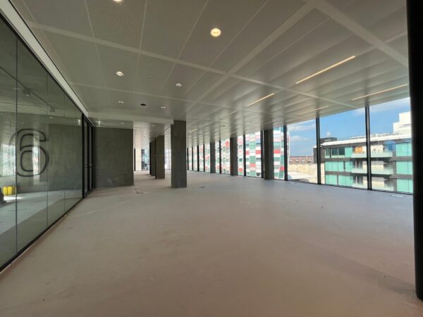Leeg kantoorpand met glazen wanden en uitzicht op moderne gebouwen aan de Catharijnesingel in Utrecht.