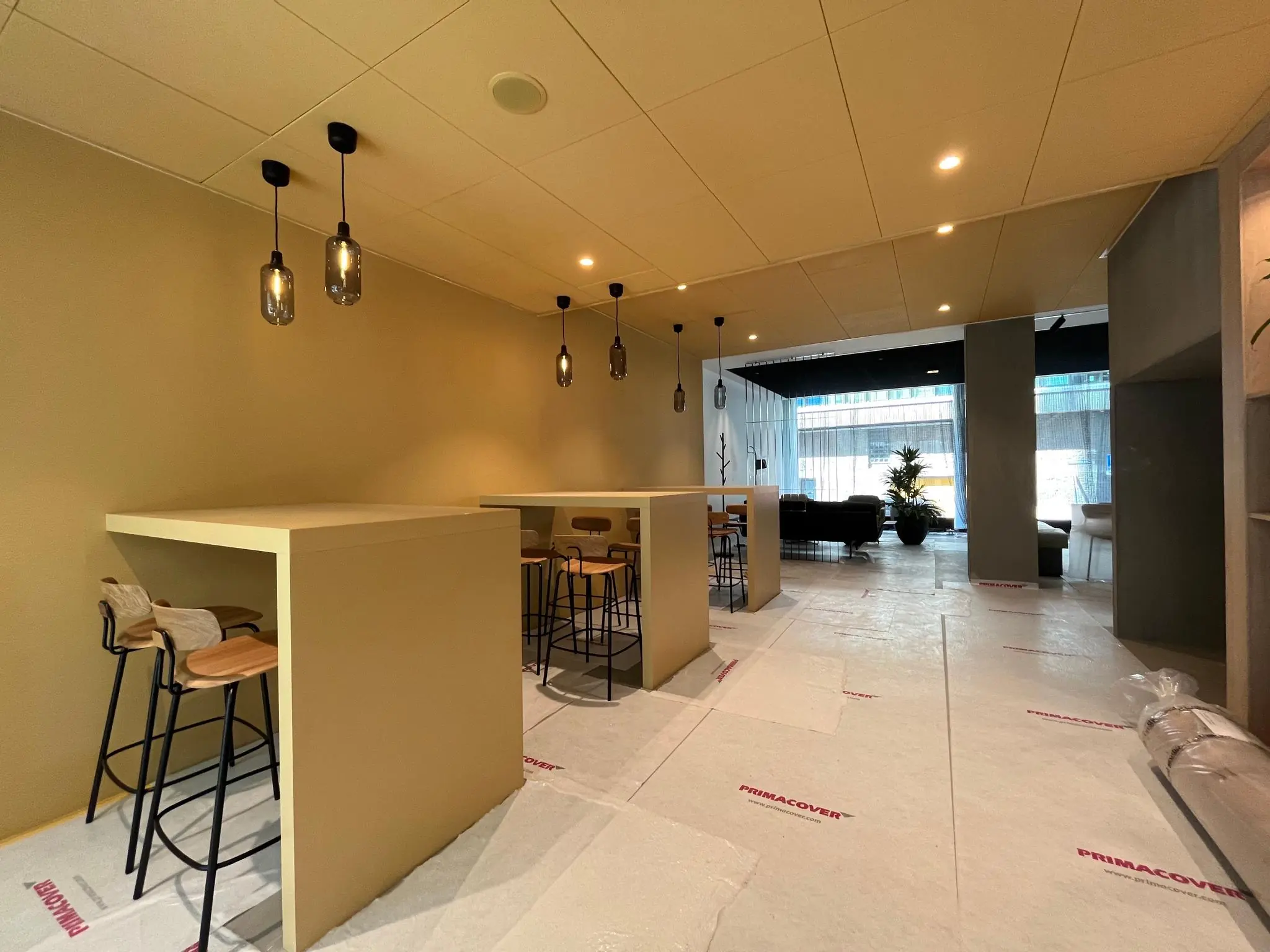 Moderne, nog in aanbouw zijnde ruimte aan de Catharijnesingel met hoge tafels, barkrukken en hanglampen.