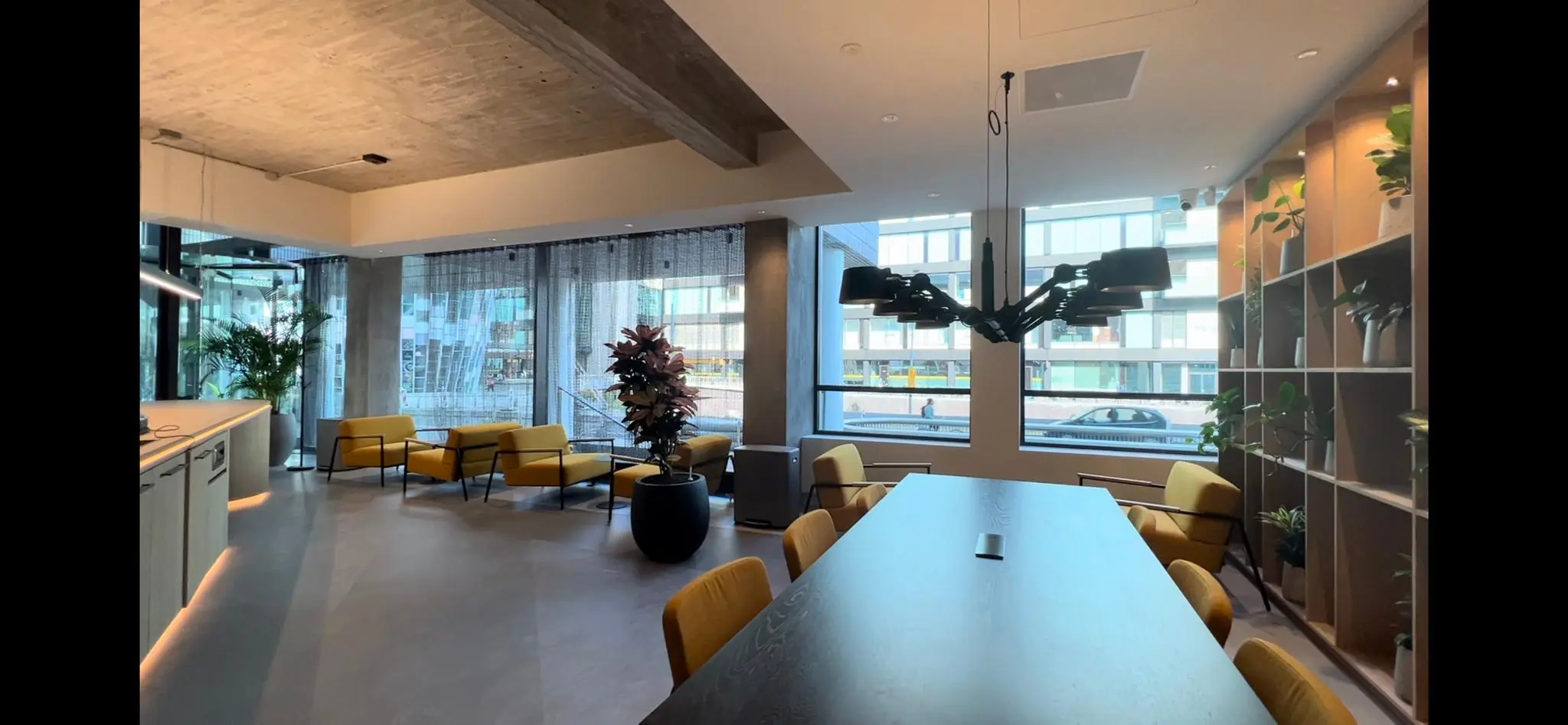 Moderne kantoorruimte aan de Catharijnesingel met gele stoelen, grote ramen en een strakke inrichting met planten.