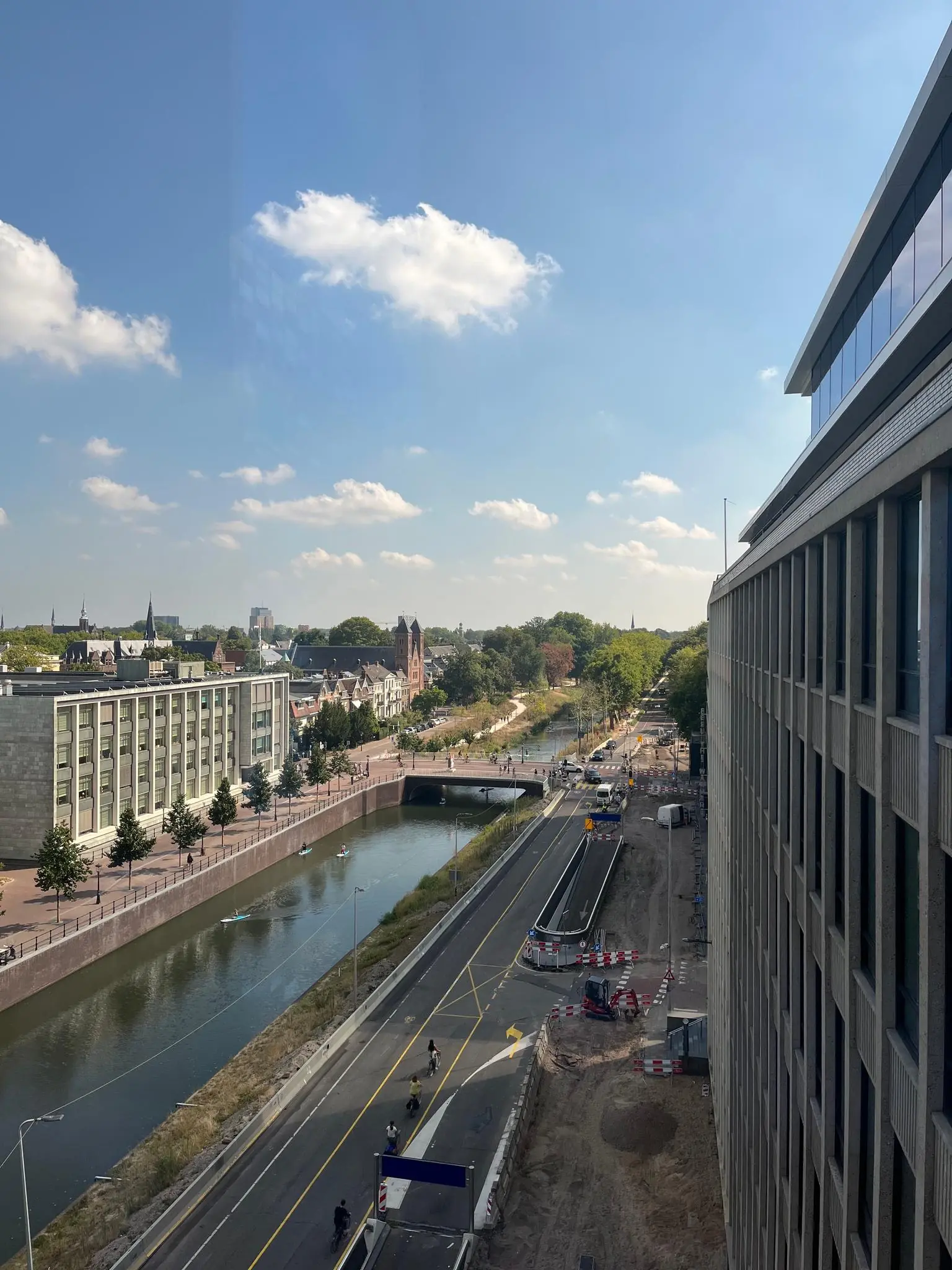 Luchtfoto van de Catharijnesingel in Utrecht met het kanaal, wegwerkzaamheden en fietsers op een zonnige dag.