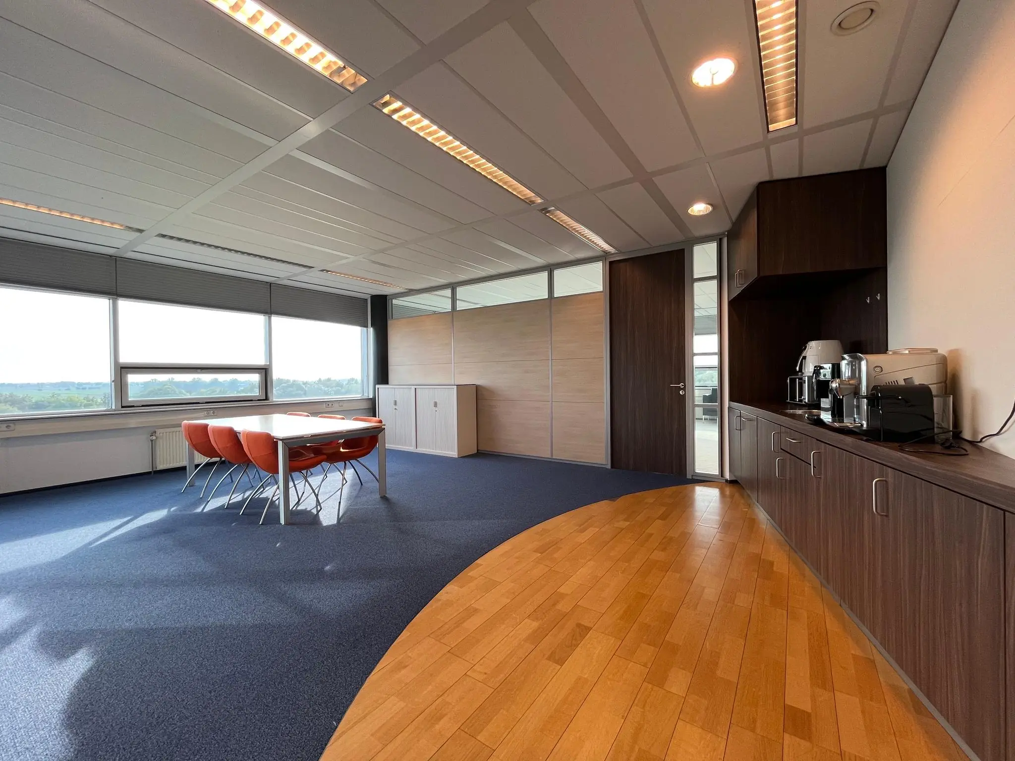 Vergaderruimte in kantoorpand Rijnzathe met vergadertafel, koffiecorner en grote ramen met uitzicht.