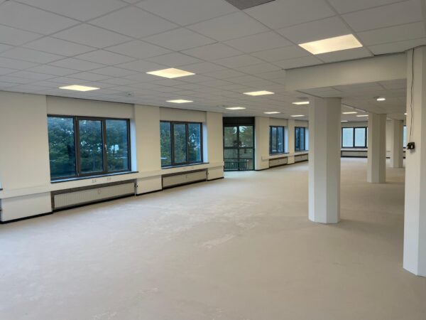 Lichte, lege kantoorruimte aan de Overschieseweg met grote ramen en systeemplafond.