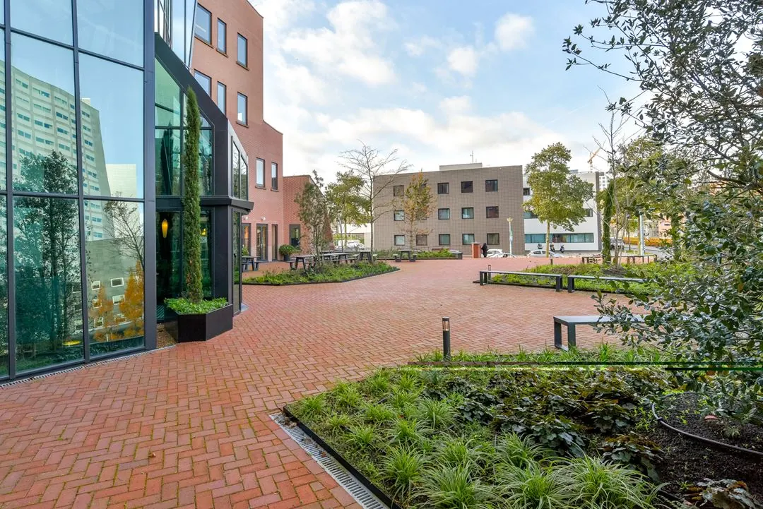 Binnenplein aan de Kingsfordweg met moderne kantoorgebouwen, rode bakstenen bestrating en groen aangelegde plantvakken.