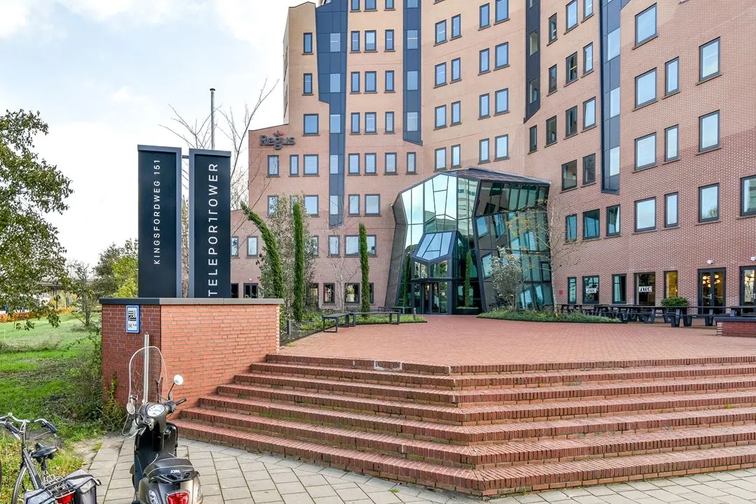 Ingang van het kantoorgebouw Teleport Tower aan de Kingsfordweg 151 in Amsterdam, met bord en trapopgang op de voorgrond.