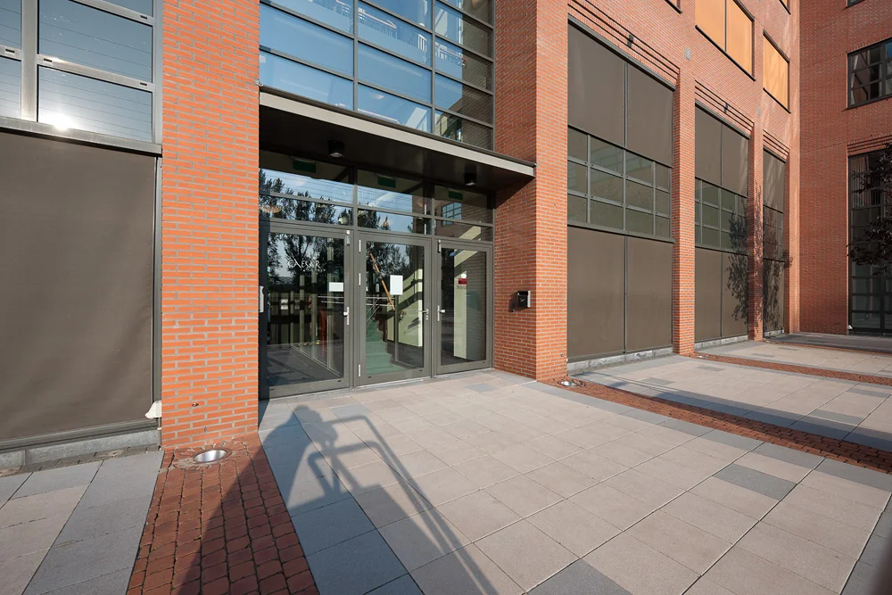 Ingang van een modern kantoorgebouw aan de Zonnebaan met glazen deuren en een gevel van rode baksteen.