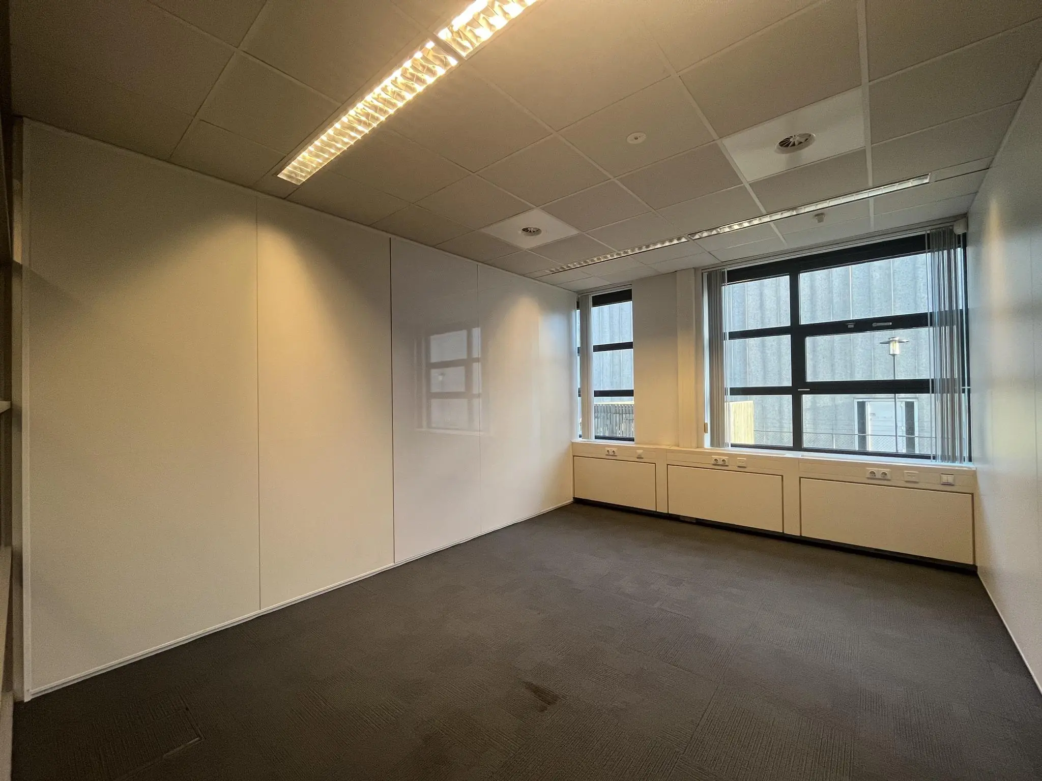 Leeg kantoorpand aan de Zonnebaan met grote ramen en systeemplafond.