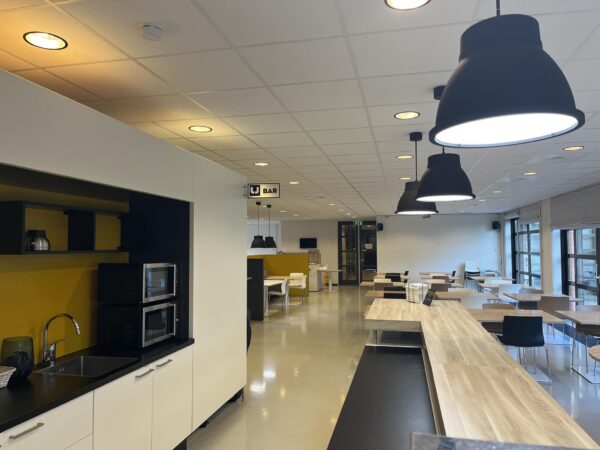 Moderne en ruime bedrijfskantine aan de Zonnebaan met open keuken, eetgedeelte en bar.