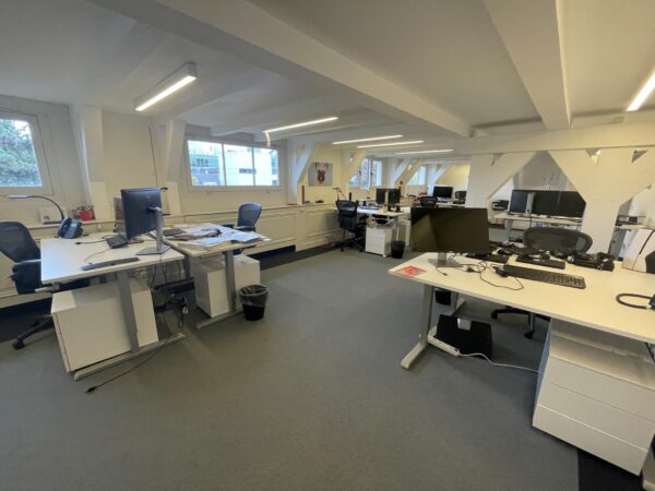 Modern kantoor met meerdere bureaus, computers en stoelen in een lichte ruimte aan de Herengracht.