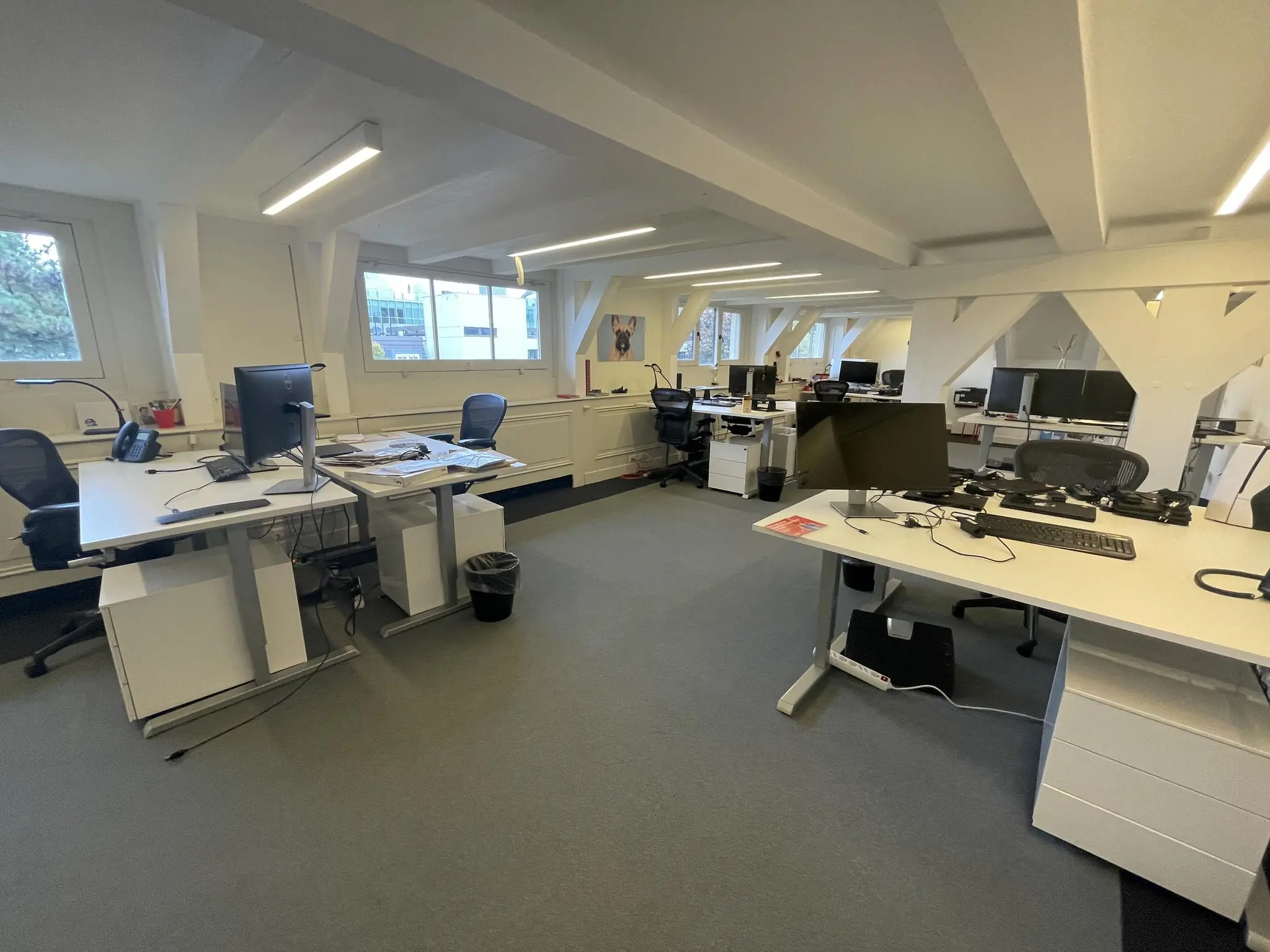 Modern kantoor met meerdere bureaus, computers en stoelen in een lichte ruimte aan de Herengracht.