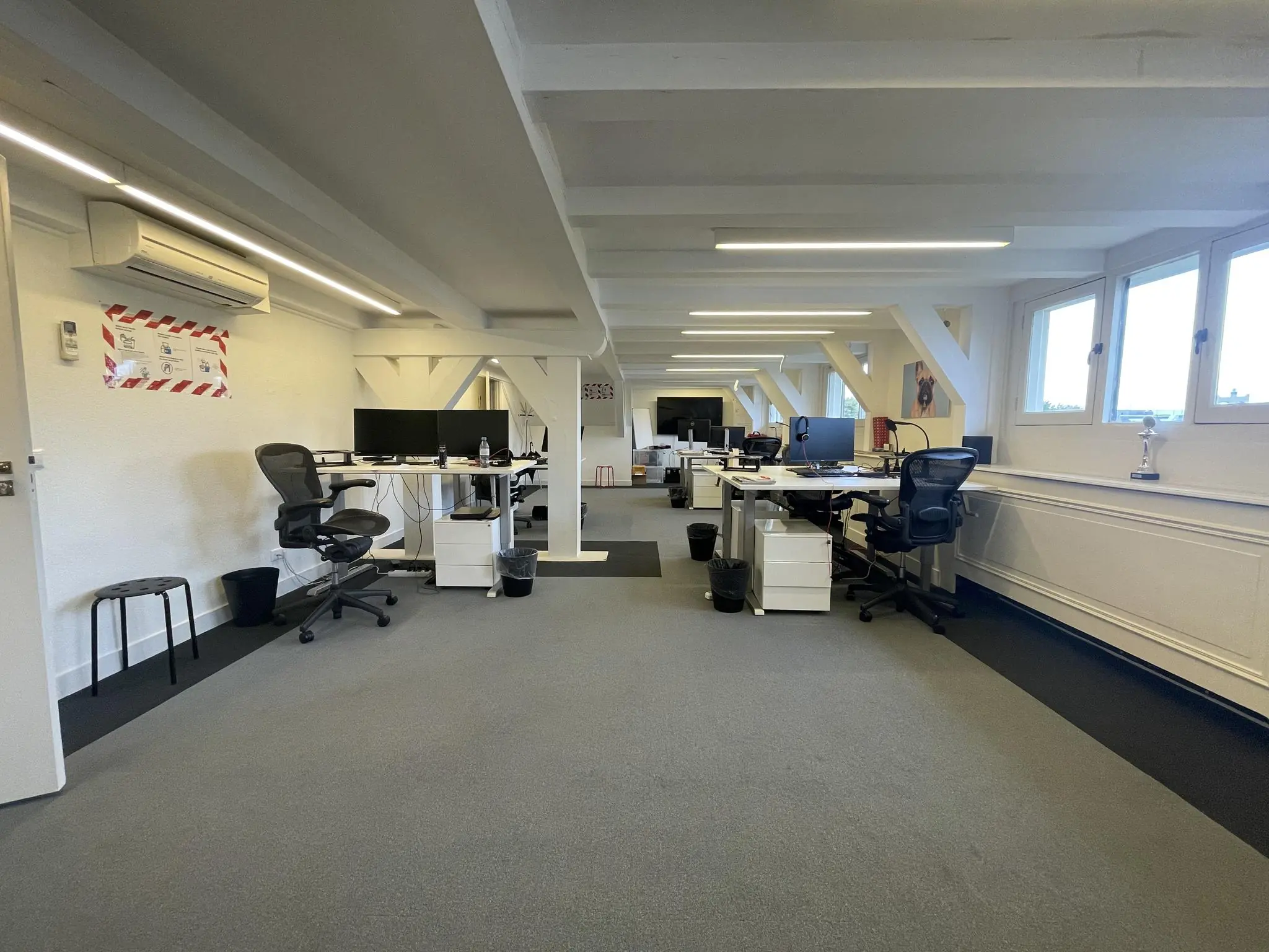 Moderne, open kantoorruimte aan de Herengracht met bureaus, ergonomische stoelen en computers.