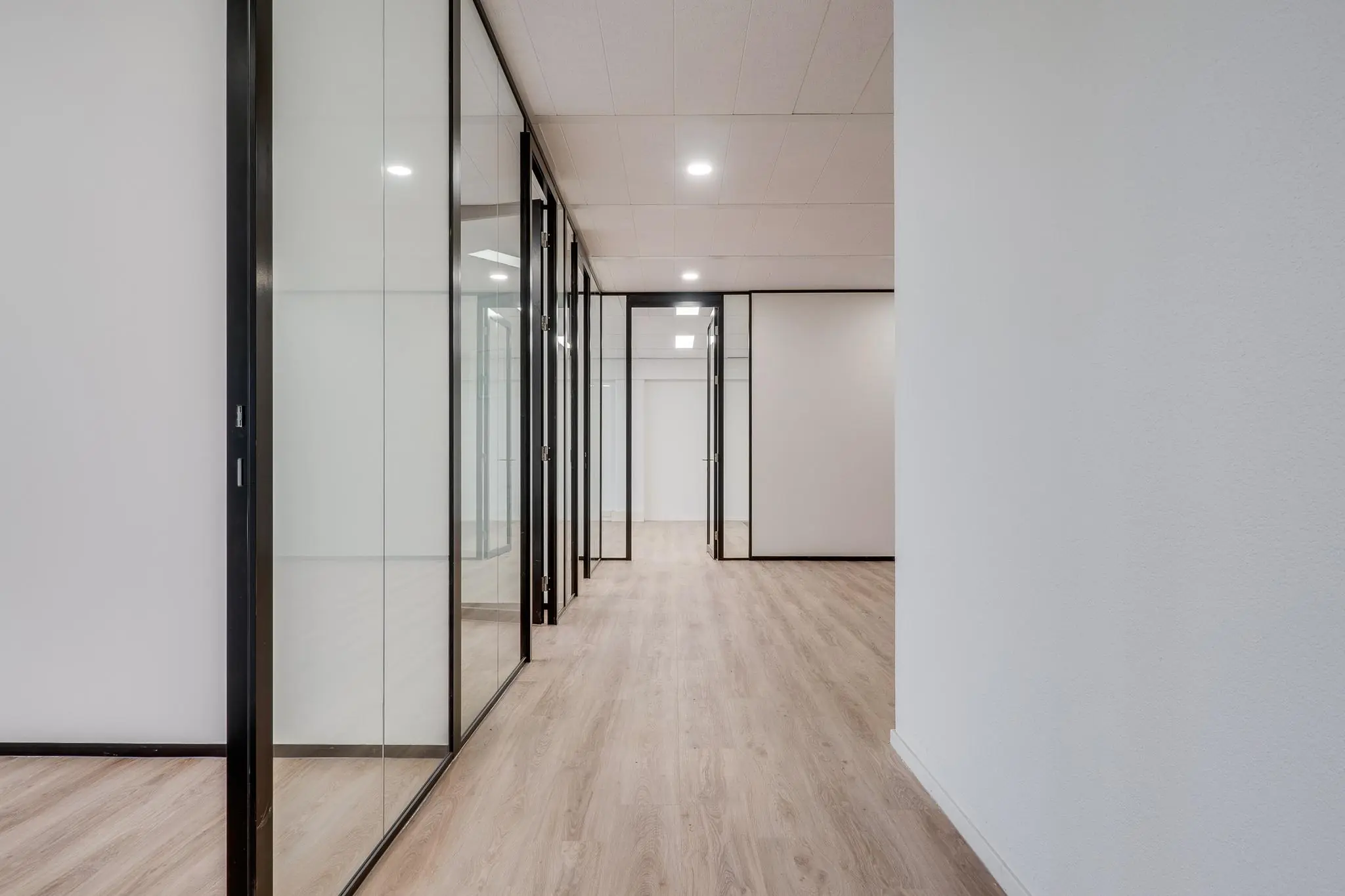 Moderne kantoorruimte aan de Zonnebaan met glazen wanden en licht houten vloer.