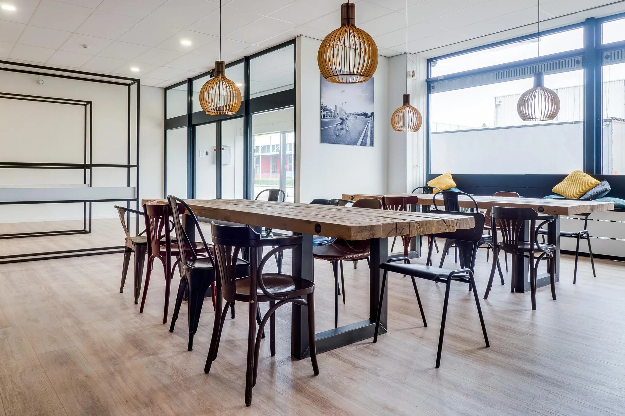 Modern ingerichte kantineruimte op Zonnebaan met houten tafels, diverse stoelen en grote ramen.