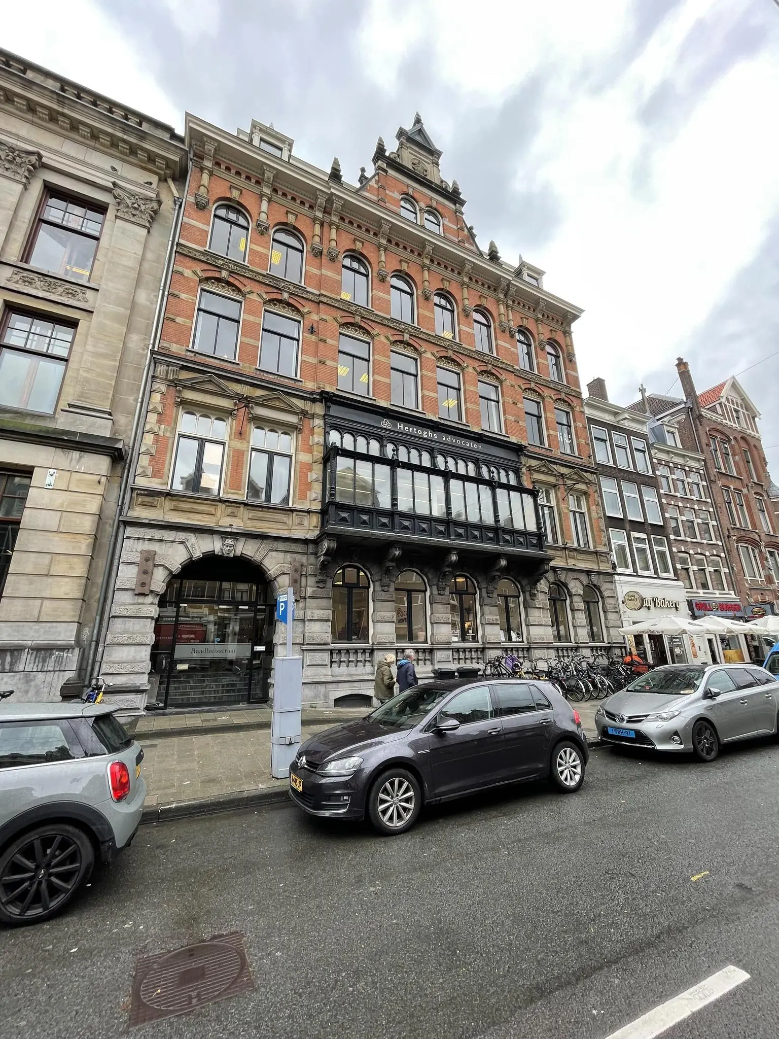 Een historisch pand aan de Raadhuisstraat in Amsterdam met het advocatenkantoor Hertoghs op de begane grond.
