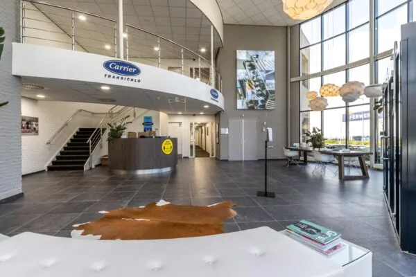 Moderne ontvangsthal van Carrier Transicold aan de Pittsburghstraat met balie, wachtruimte en grote raampartijen.