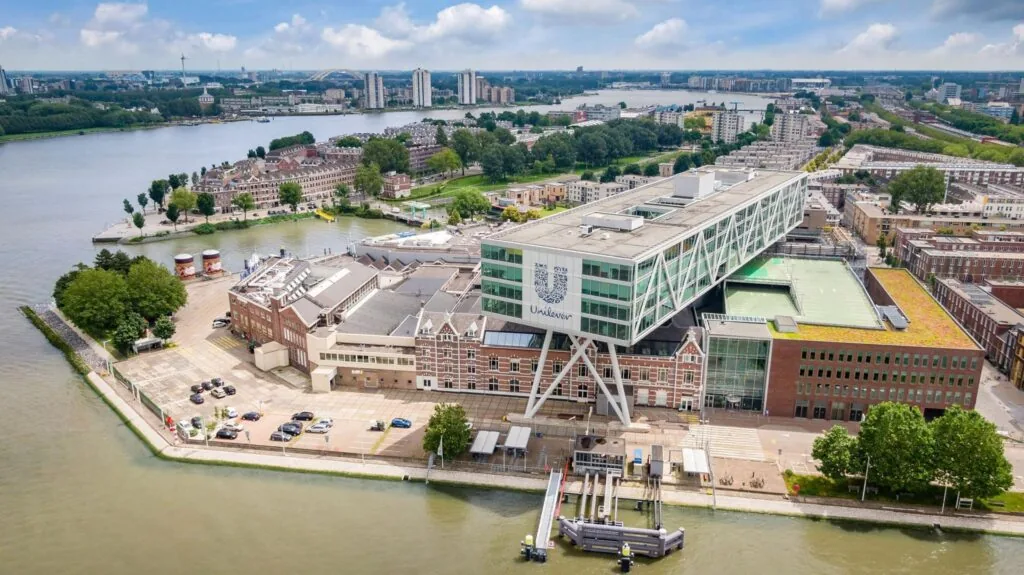 Luchtfoto van het Unilever-kantoor aan de Nassaukade in Rotterdam, gelegen aan de oevers van de rivier.