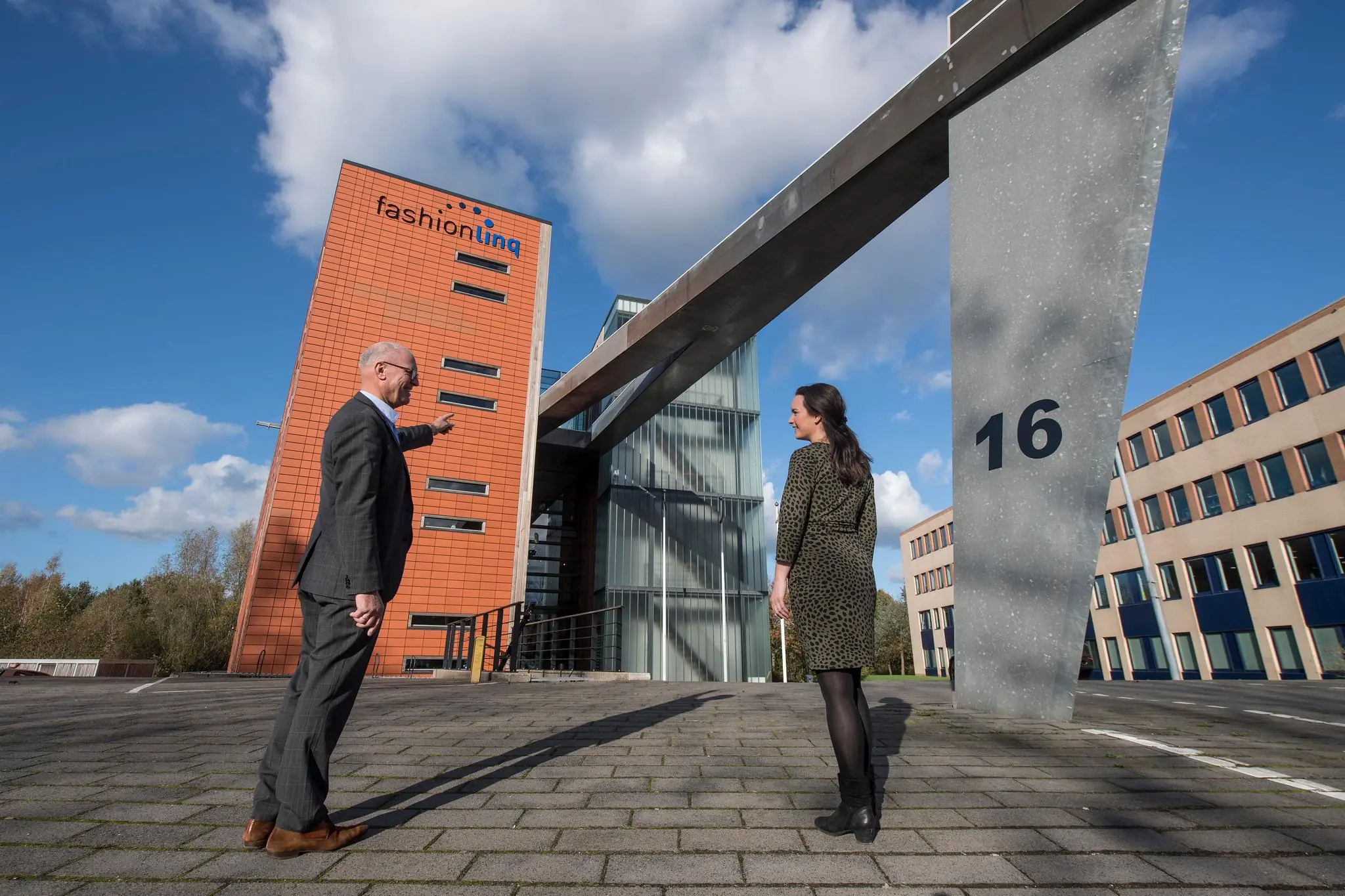 Twee mensen staan voor het kantoorpand van Fashionlinq aan de Fokkerstraat 16.