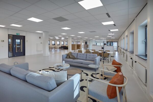 Modern ingerichte, open kantooruimte aan de Joop Geesinkweg met zithoeken en werkplekken.