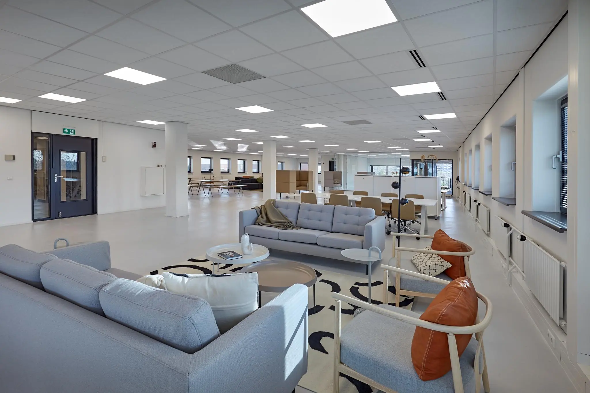 Modern ingerichte, open kantooruimte aan de Joop Geesinkweg met zithoeken en werkplekken.