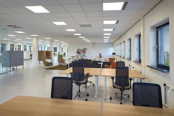 Moderne, open kantoorruimte aan de Joop Geesinkweg met werkplekken, zithoeken en grote ramen.