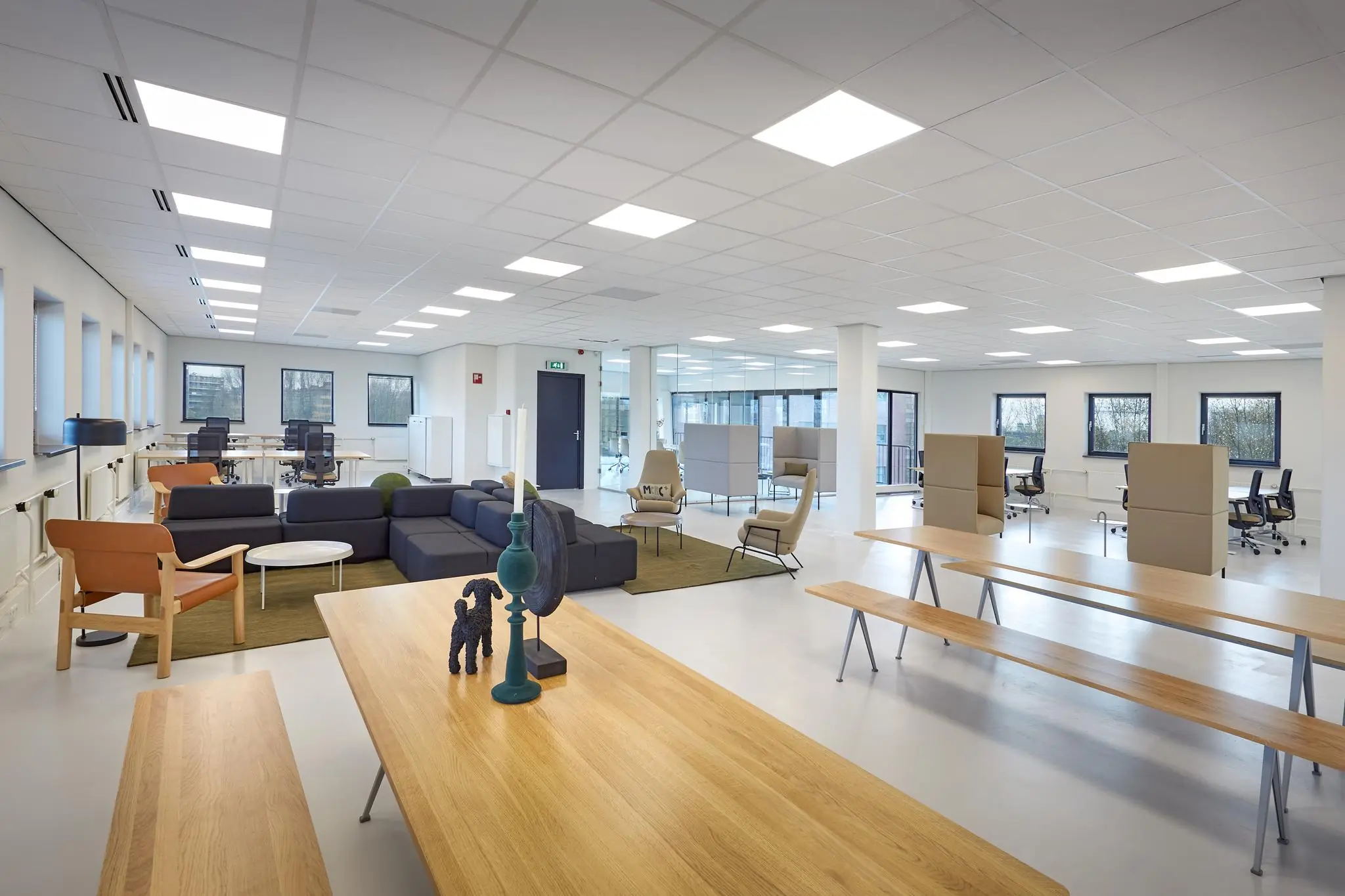 Modern en ruim kantoorinterieur aan de Joop Geesinkweg met flexplekken, zithoeken en lange houten tafels.