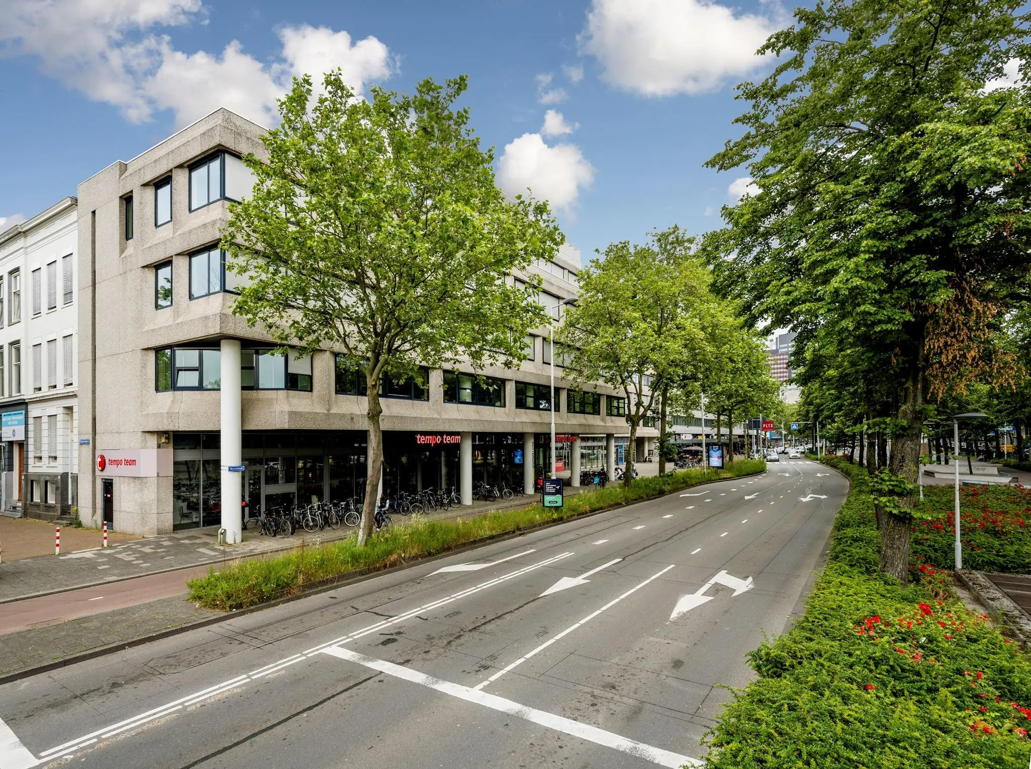 Straatbeeld van de Westblaak in Rotterdam met Tempo-Team kantoor en omliggende groenstroken.