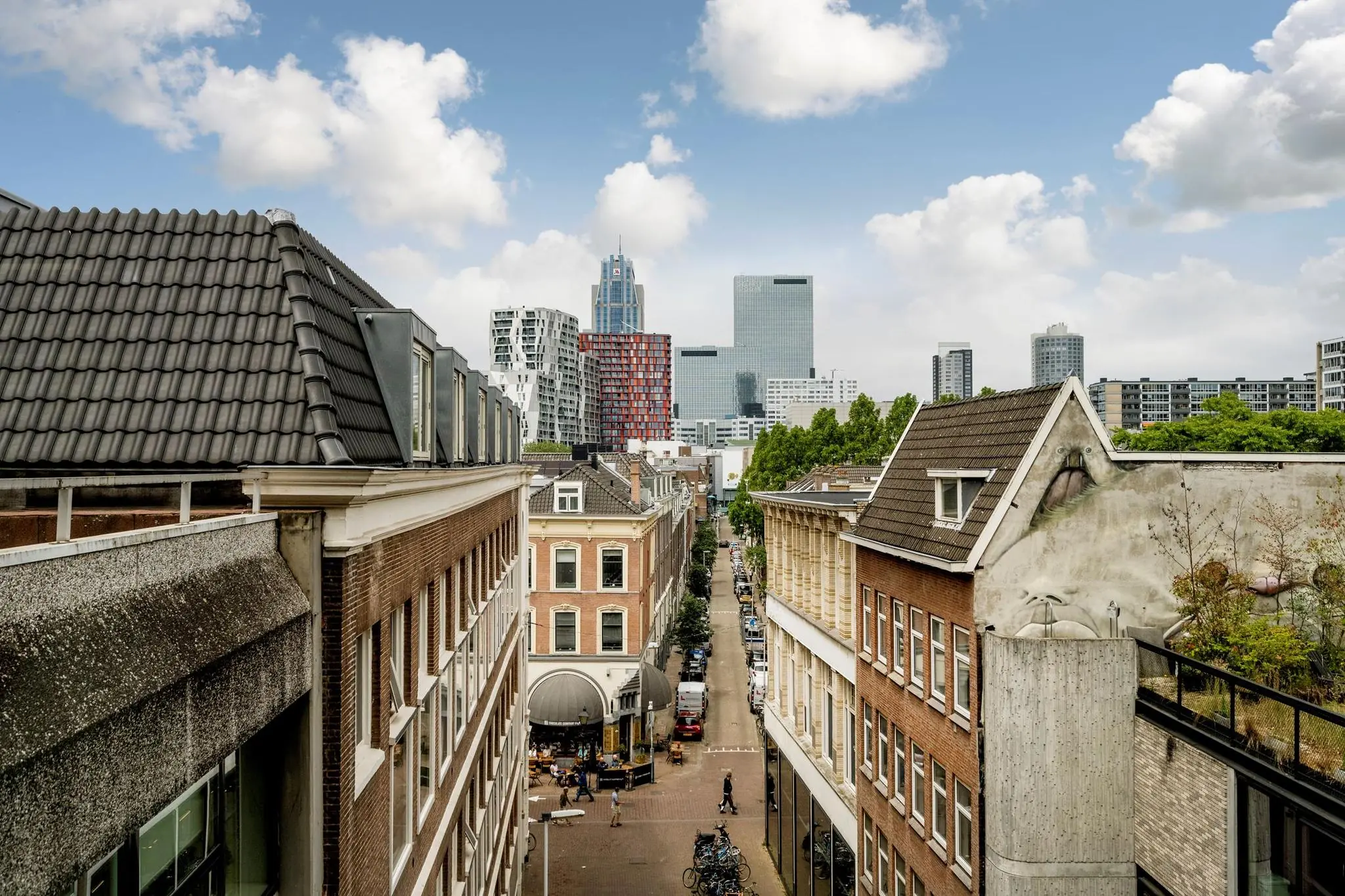 Uitzicht op de Westblaak in Rotterdam met een mix van historische panden en moderne hoogbouw op de achtergrond.