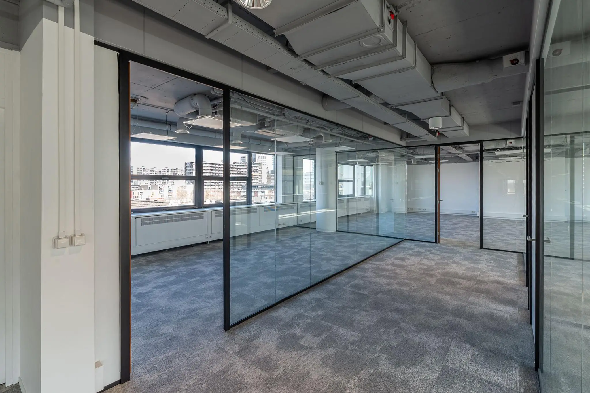 Modern, leeg kantoorpand aan de Westblaak met glazen wanden en zicht op de stad.