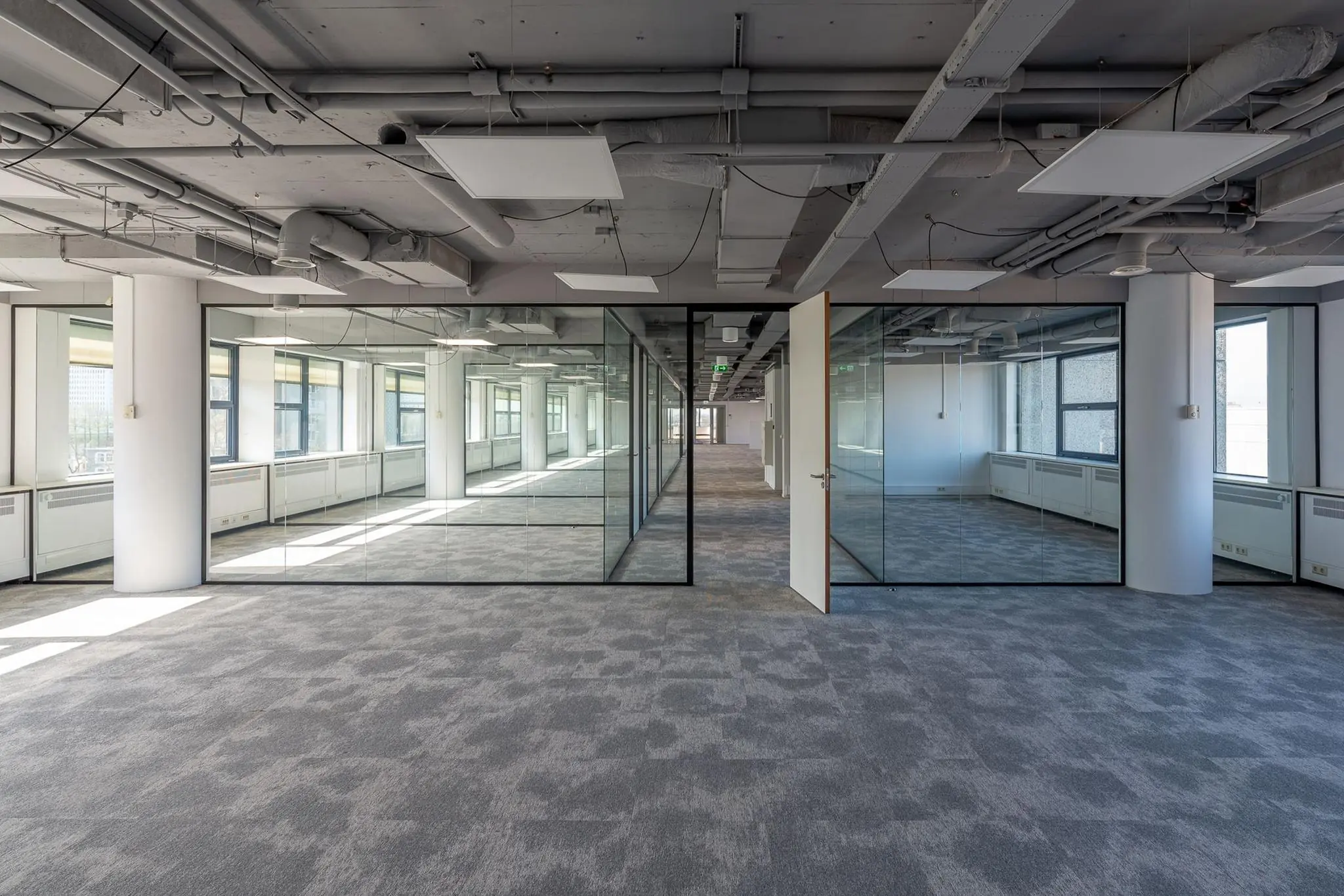 Licht en modern kantoorpand aan de Westblaak met glazen wanden en industriële plafonds.