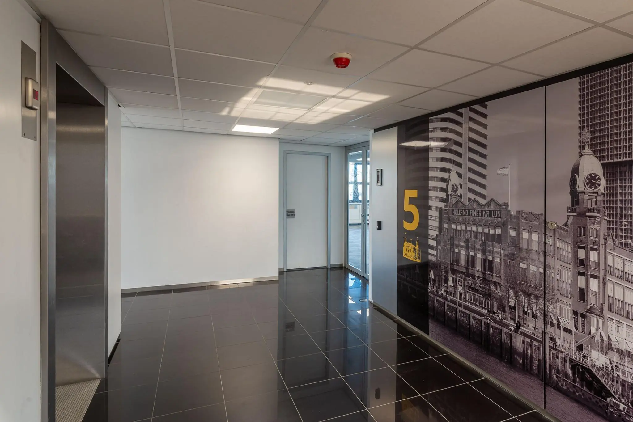 Moderne kantoorgang op de vijfde verdieping van Westblaak met liftdeur en zwart-witte muurdecoratie van Rotterdam.