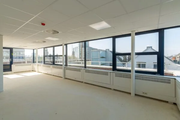 Lichte, lege kantoorruimte aan de Westblaak met grote ramen en uitzicht op de skyline van Rotterdam.