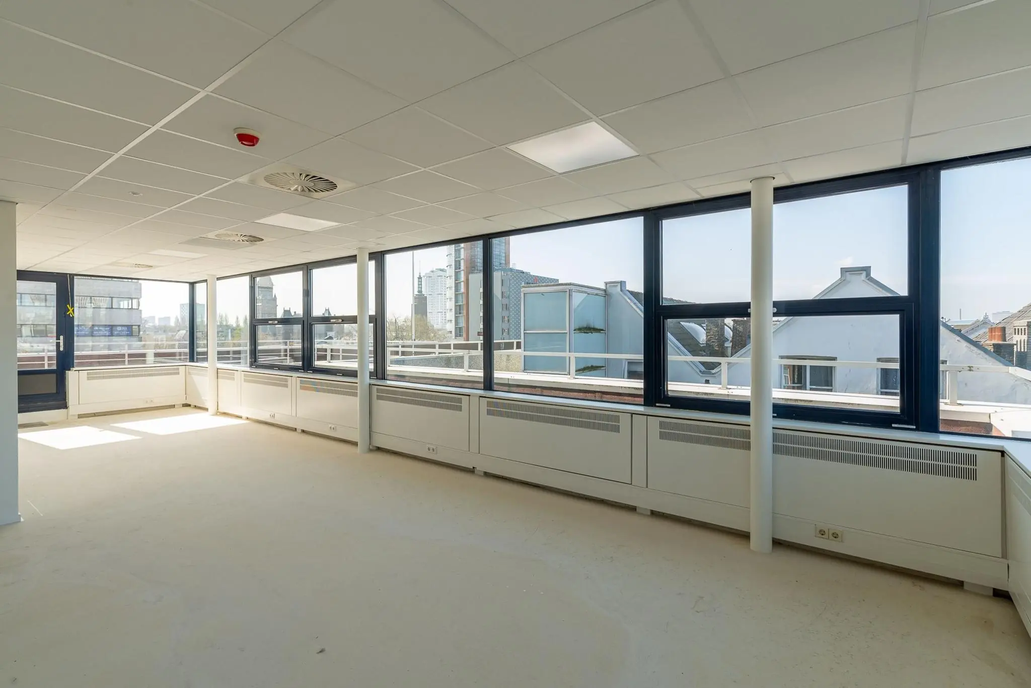Lichte, lege kantoorruimte aan de Westblaak met grote ramen en uitzicht op de skyline van Rotterdam.