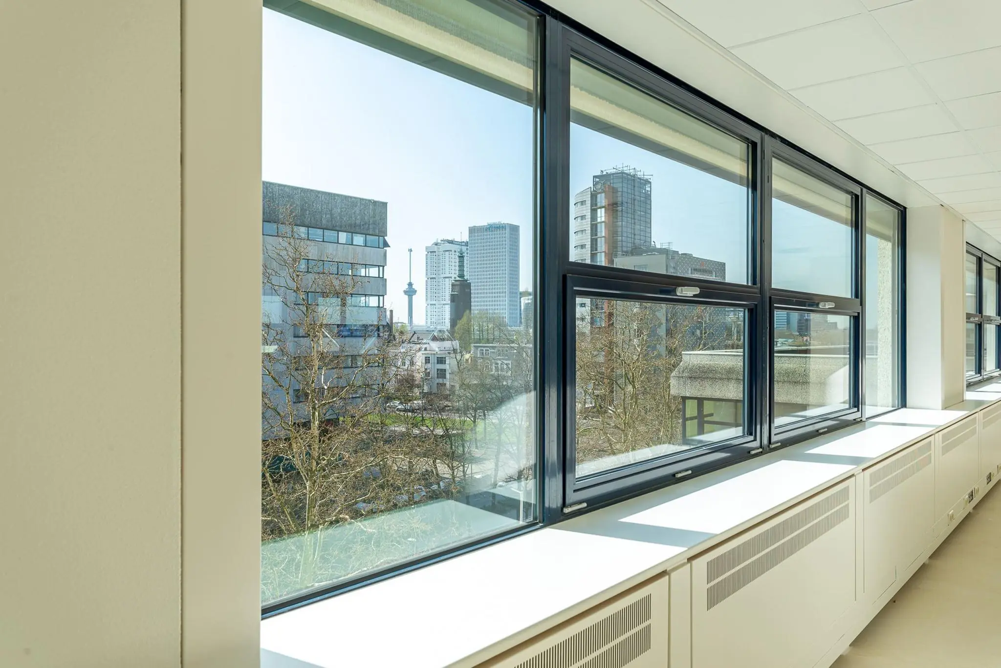 Uitzicht vanuit een binnenruimte op de Rotterdamse skyline met onder andere de Euromast, gezien vanaf Westblaak.