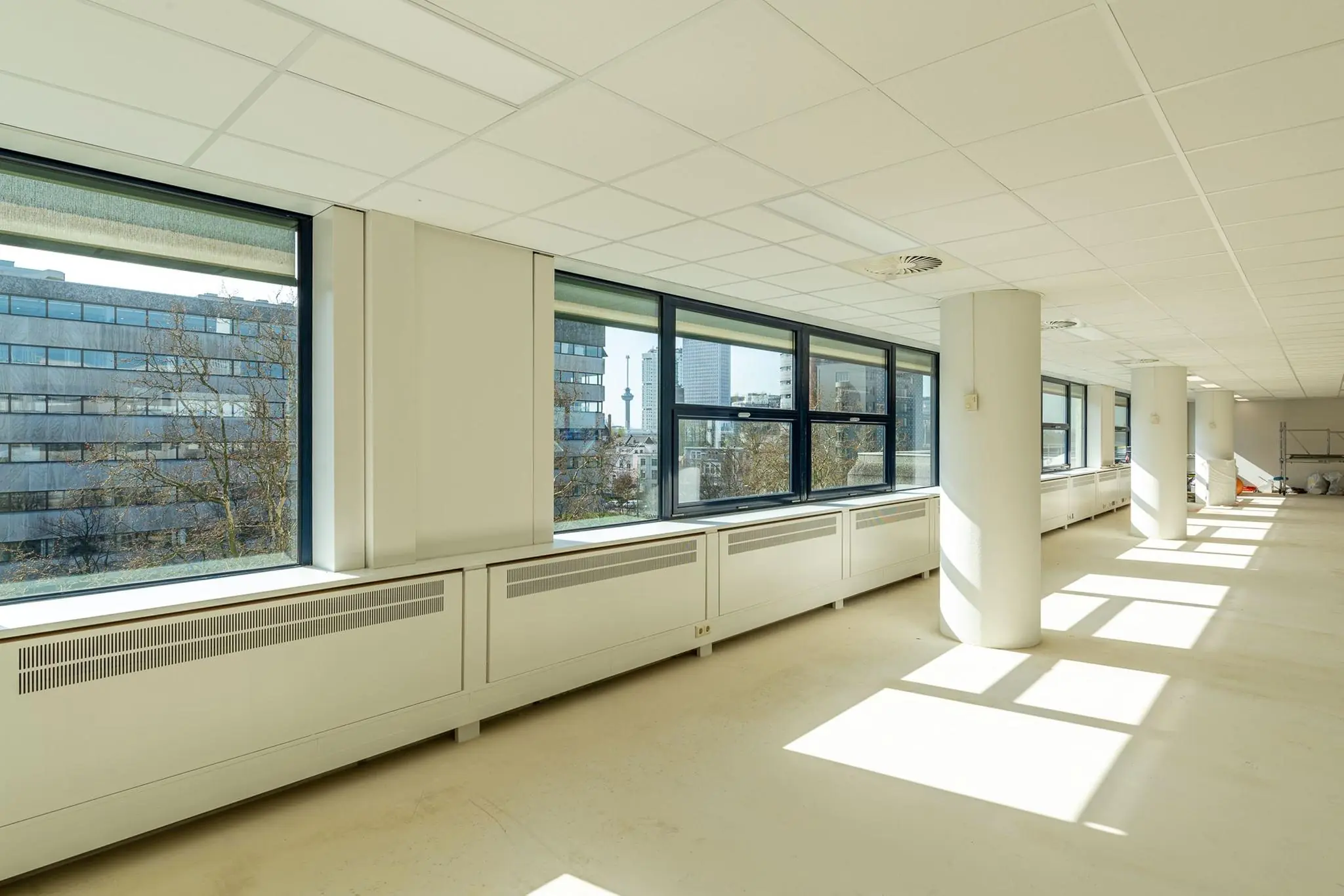 Licht en leeg kantoorinterieur aan de Westblaak met grote ramen en uitzicht op Rotterdamse kantoorgebouwen.