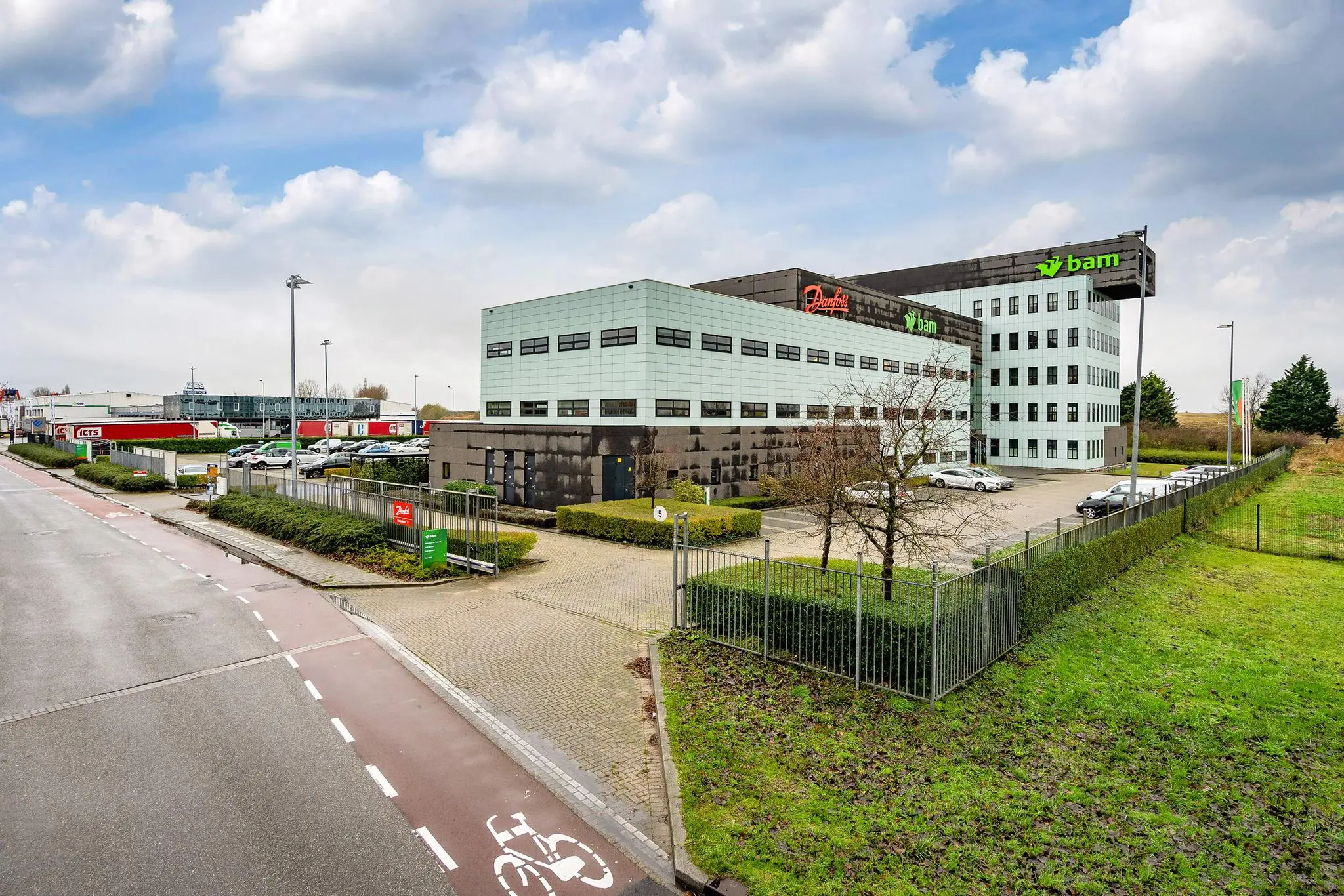 Kantoorcomplex aan de Vareseweg met de bedrijfslogo’s van Danfoss en BAM, omringd door een parkeerterrein en groenvoorziening.