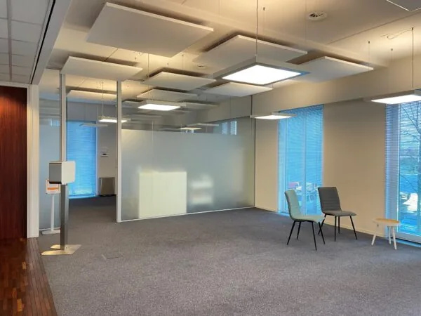 Moderne wachtruimte in kantoorgebouw aan de Linatebaan met stoelen, bijzettafeltje en glazen wanden.