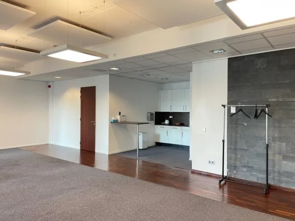 Moderne kantoorruimte aan de Linatebaan met open keuken, donkerhouten vloer en kapstok.