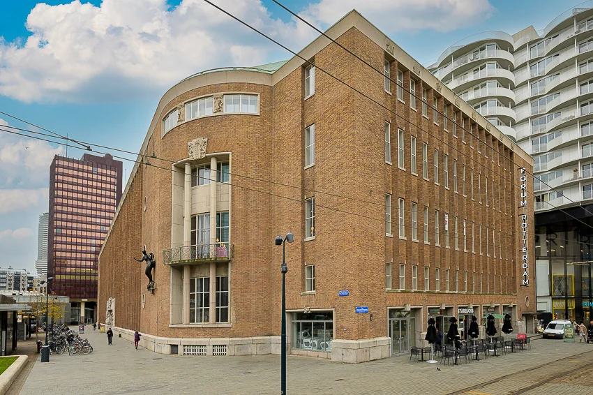 Het historische stadhuis aan de Coolsingel in Rotterdam met het moderne Forum Rotterdam en een Starbucks op de begane grond.