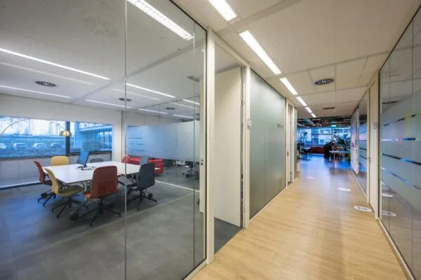Moderne kantoorruimte aan de Naritaweg met glazen vergaderruimtes en een lichte gang.