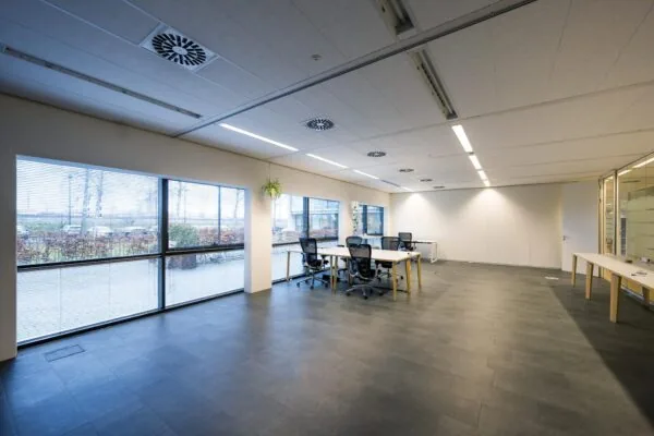 Moderne, lichte kantoorruimte aan de Naritaweg met werkplekken en grote ramen met uitzicht naar buiten.