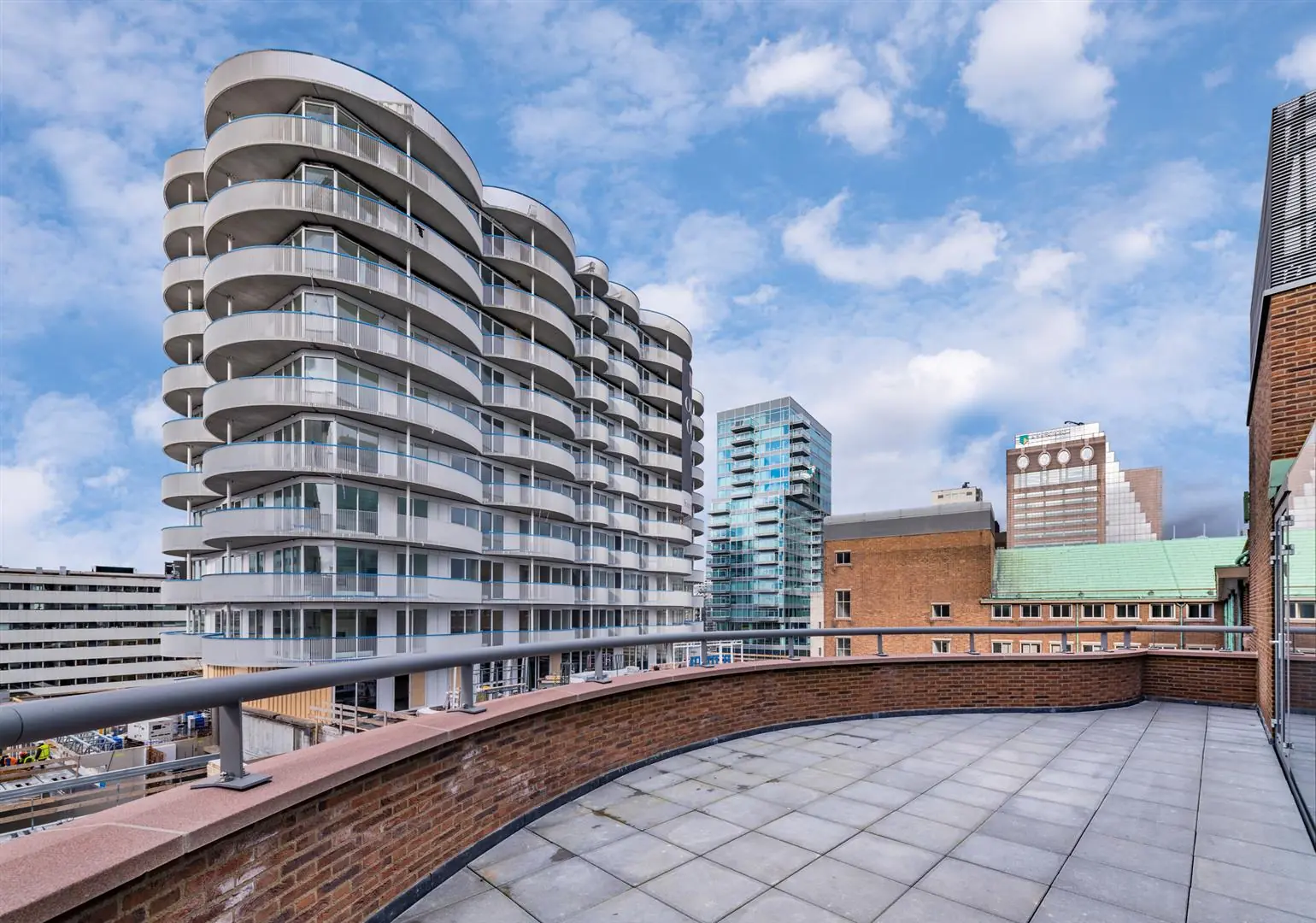 Uitzicht vanaf een ruim dakterras op de moderne appartementencomplexen aan de Coolsingel in Rotterdam.