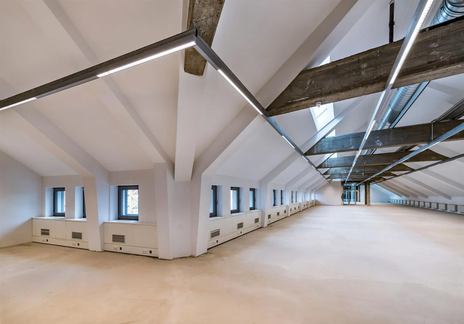 Ruime, modern gerenoveerde zolderverdieping aan de Coolsingel met zichtbare houten balken en strakke verlichting.