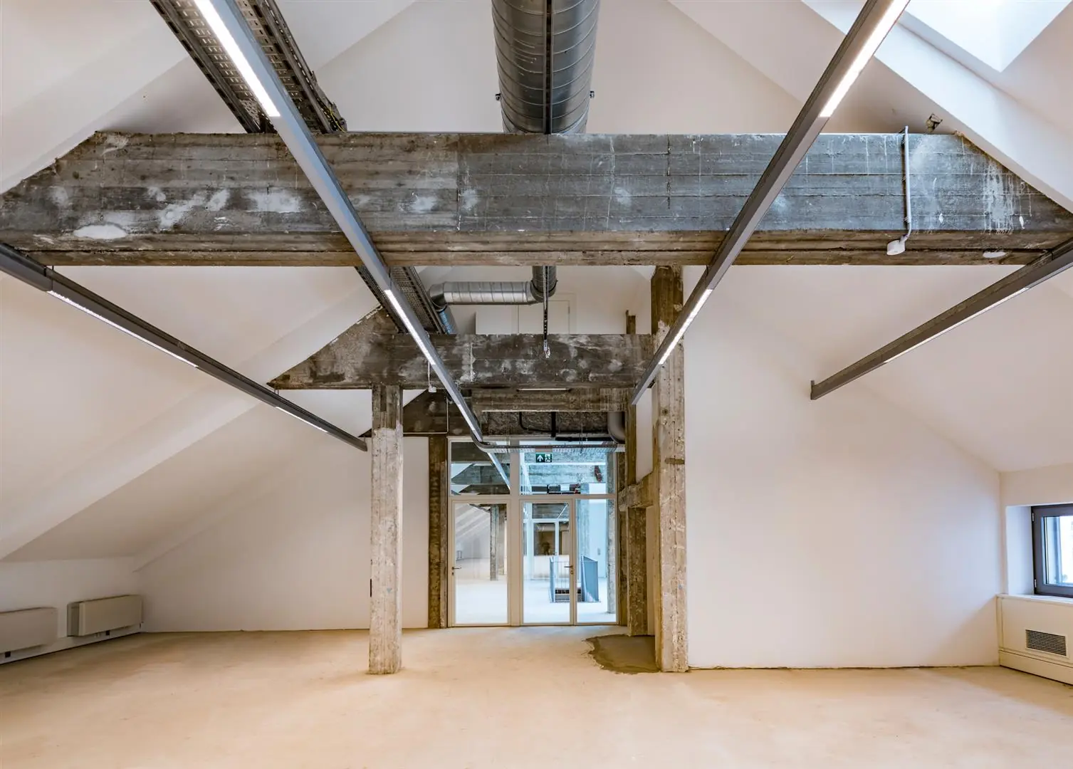 Modern gerenoveerde zolderruimte aan de Coolsingel met zichtbare betonnen draagconstructie en strakke afwerking.