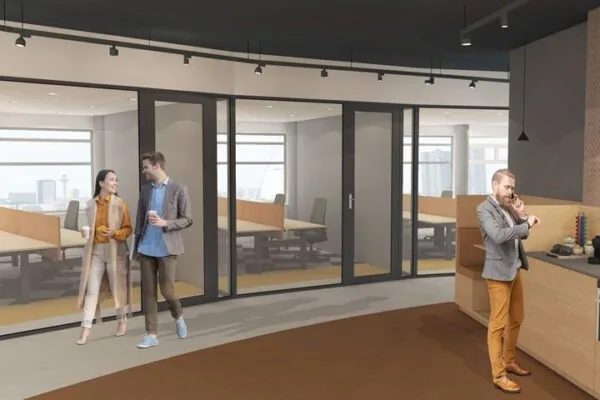 Twee mensen lopen door een moderne kantoorruimte aan het Wilhelminaplein, terwijl een derde persoon bij een balie telefoneert.