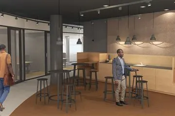 Moderne kantoorruimte op het Wilhelminaplein met een zithoek, barkrukken en twee personen.