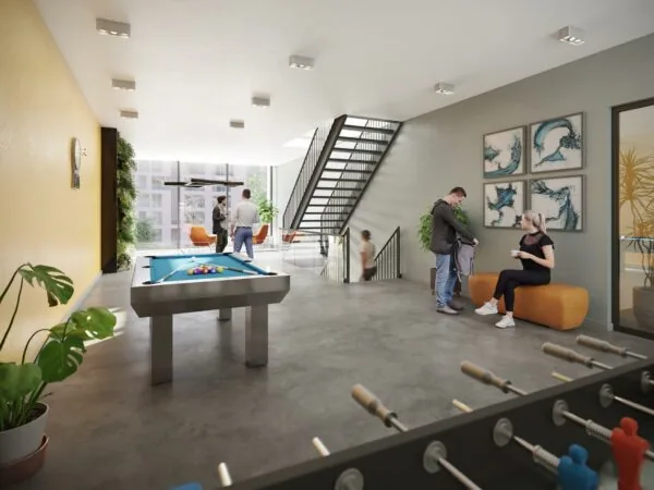 Moderne gemeenschappelijke ruimte aan de Treubstraat met een biljarttafel, tafelvoetbal en zithoeken waar mensen ontspannen.