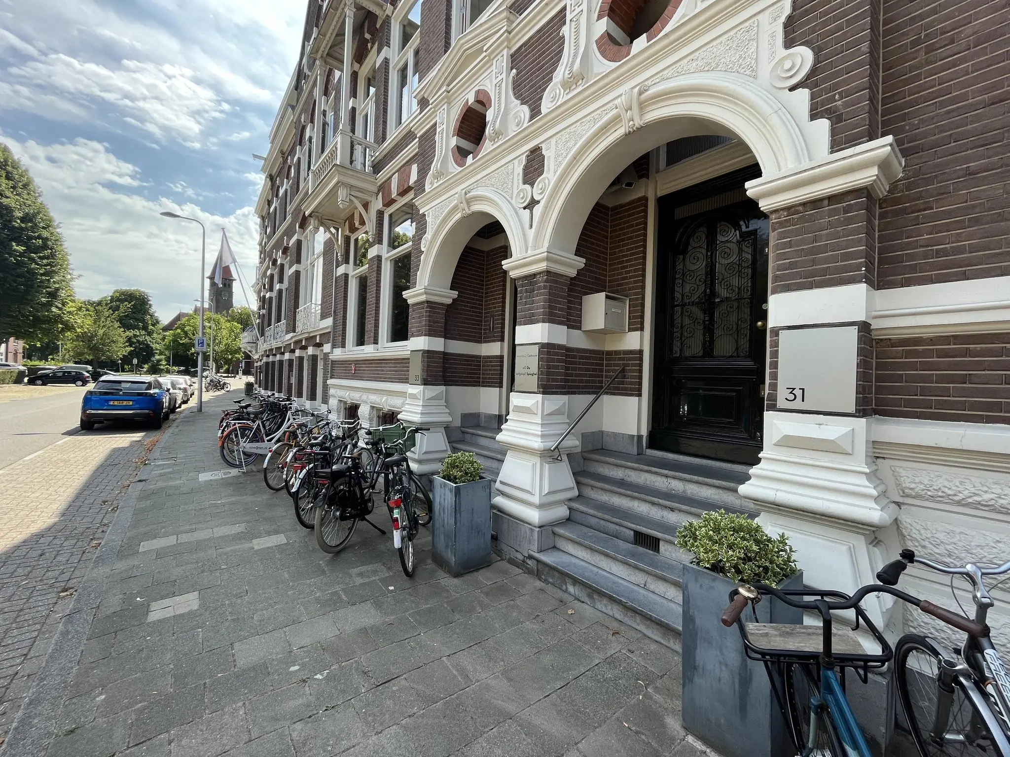Gevel van een klassiek herenhuis aan de Ramstraat in Utrecht met fietsen geparkeerd langs de stoep.