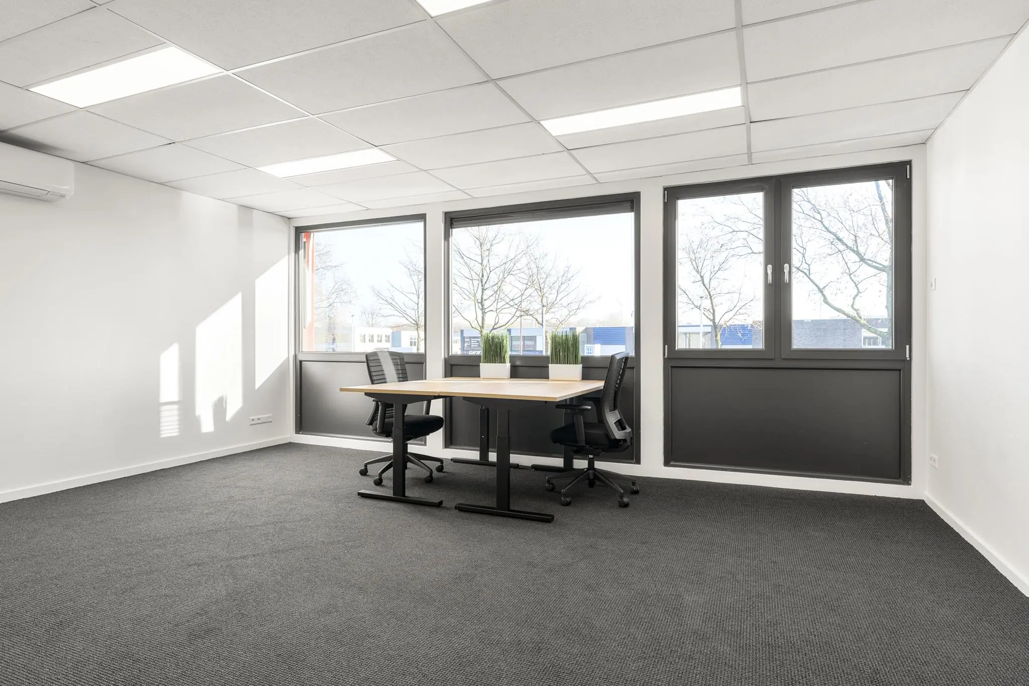 Licht en modern kantoor met twee bureaustoelen en grote ramen aan de Nijverheidsweg.